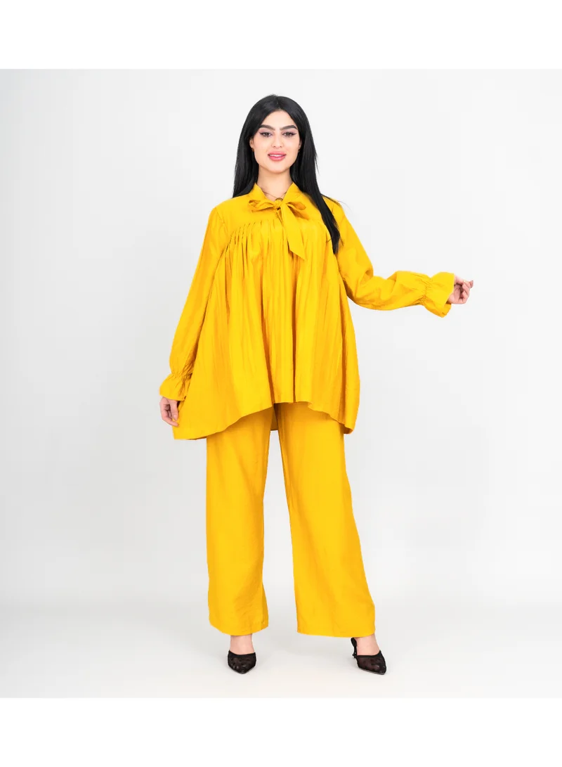 اكسا طقم عصري من قطعتين، بلوزة وبنطال بلون موحد، مزين بفيونكة